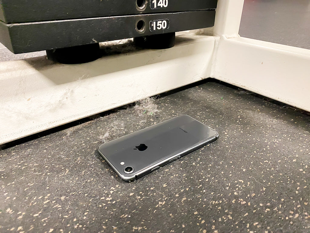 Phone laying on the gym floor next to a weight machine